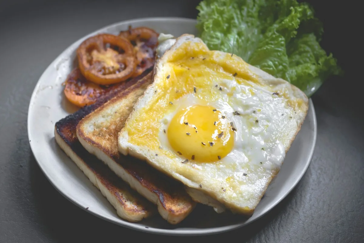 Breakfast plate with fried egg, toast, tomatoes and greens
