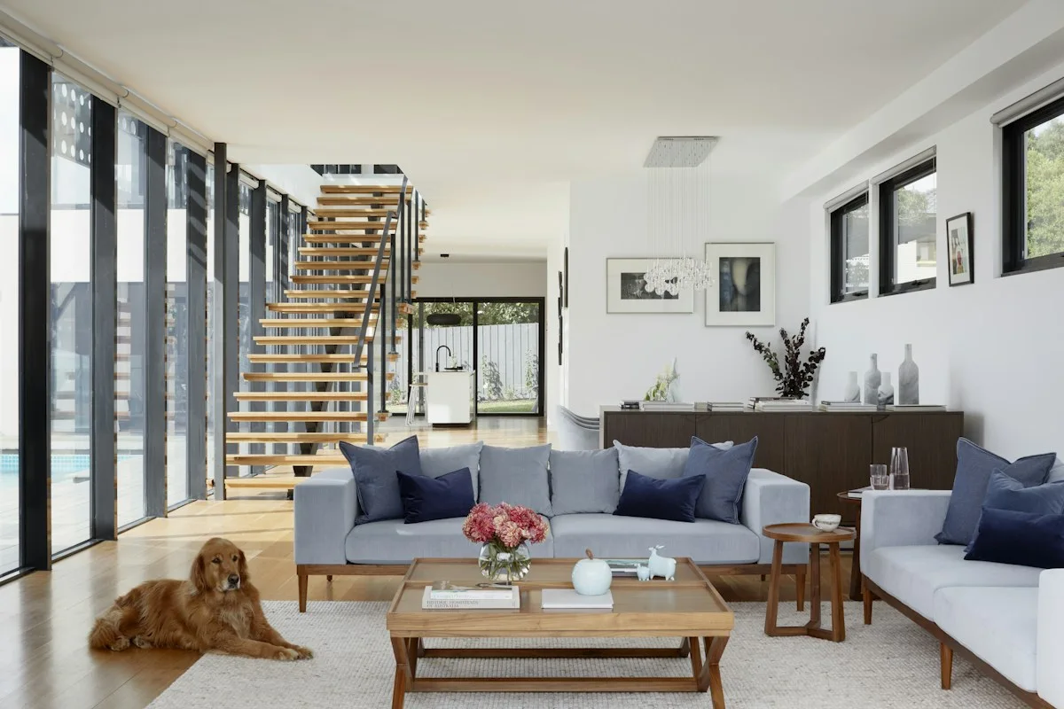 Open-plan home with stairs, pale sofa and wooden coffee table